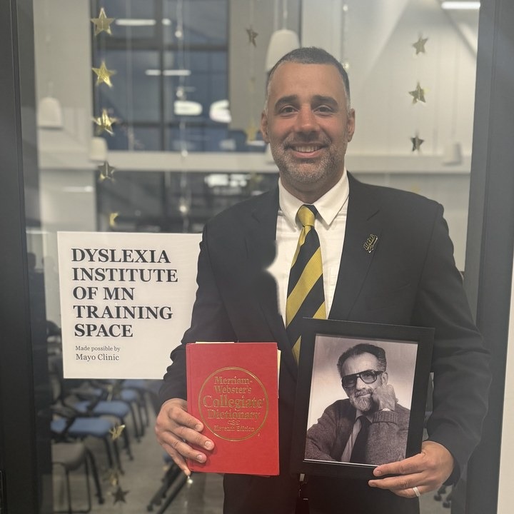 Shawn Anthony Robinson, PhD holding a Merriam-Webster dictionary at the Dyslexia Institute of Minnesota